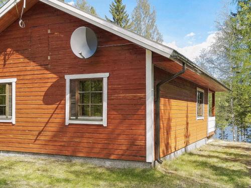 a wooden house with a window and a door at Holiday Home Aamunsarastus by Interhome in Savonranta
