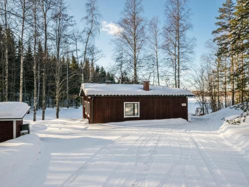 a cabin in the snow with trees in the background at Holiday Home 2235 by Interhome in Savonranta