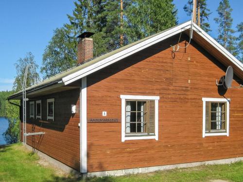 a wooden house with two windows and a chimney at Holiday Home Aamunsarastus by Interhome in Savonranta