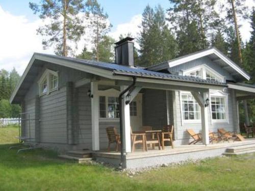 a small house with a porch and a table at Holiday Home Varvali by Interhome in Lahdenkylä