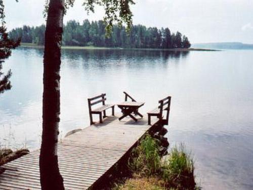 Holiday Home Harakanpesä by Interhome في Saalahti: رصيف خشبي مع طاولة نزهة على البحيرة