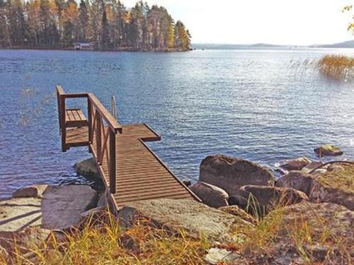 a wooden staircase leading into a lake with rocks at Holiday Home Ylä-hannala by Interhome in Muurame