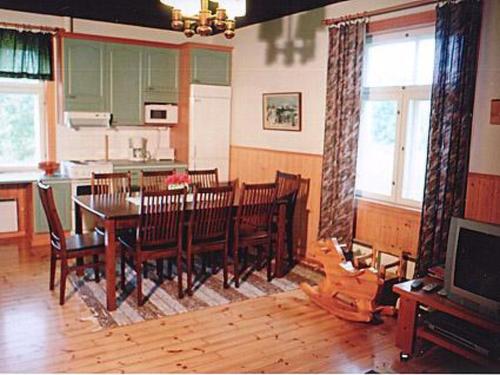 une salle à manger avec une table, des chaises et une télévision dans l'établissement Holiday Home Jokiranta by Interhome, à Armisvesi