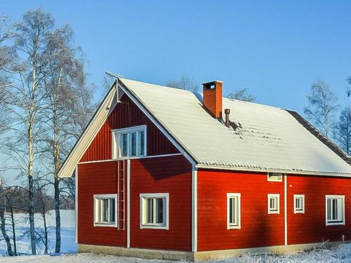 een rood huis met een dak in de sneeuw bij Holiday Home Tervaleppä by Interhome in Torvoila
