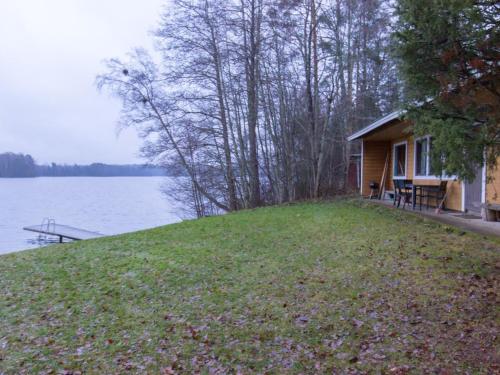 une maison sur une colline à côté d'une masse d'eau dans l'établissement Holiday Home Vattomäki, à Sorrinmäki