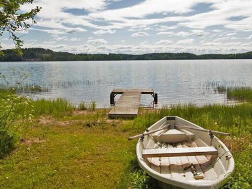 a boat on the shore of a lake with a dock at Holiday Home Keltavuokko by Interhome in Sipsiö