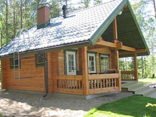 eine Blockhütte mit einer Veranda und einem Dach in der Unterkunft Holiday Home Pikkutupa by Interhome in Hyyrylä