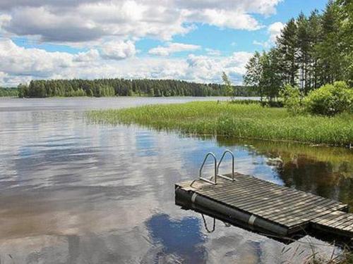 a wooden dock in the middle of a lake at Holiday Home Joutsenlahti by Interhome in Pätiälä
