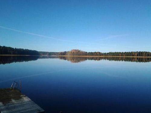 ein großer Wasserkörper mit einem Holzsteg in der Unterkunft Holiday Home Kopinkallio 3 by Interhome in Pätiälä