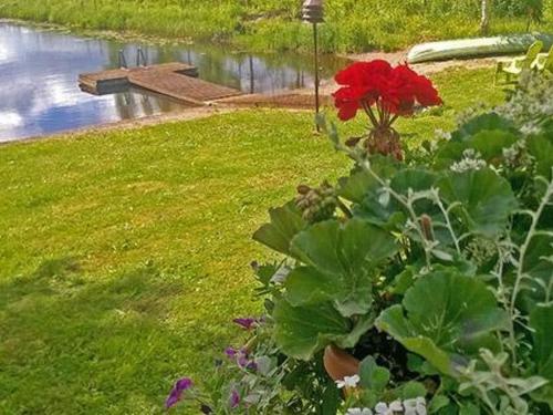 TammelaにあるHoliday Home Kuivajärven huvilakoti by Interhomeの池の横の庭の赤花