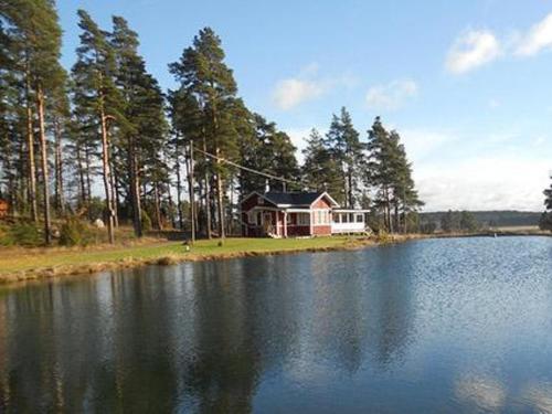 a house sitting on the side of a lake at Holiday Home Vauvila by Interhome in Kyynämäki