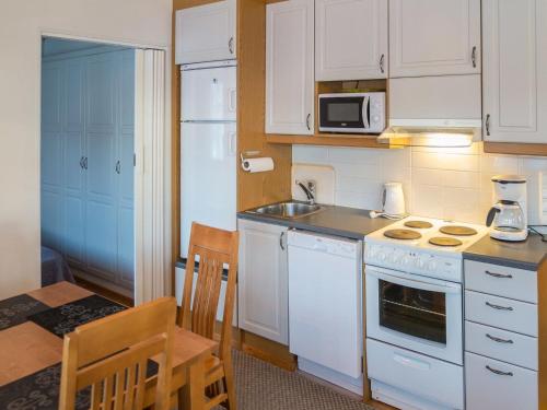 een keuken met witte kasten, een wastafel en een fornuis bij Holiday Home Point vale 2 ap- 5 by Interhome in Tahkovuori