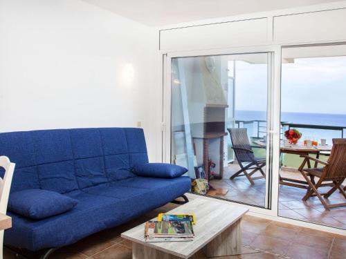 a blue couch in a living room with a view of the ocean at Apartment Vermell-8 by Interhome in Platja  d'Aro