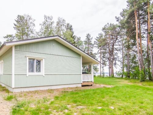 una casa verde con porche en un patio en Holiday Home Petäjäniemi by Interhome, en Leskelä