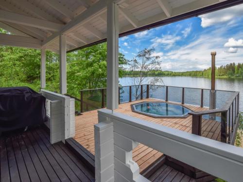 un porche cubierto con bañera de hidromasaje en un lago en Holiday Home Orijärvi by Interhome, en Mikkeli