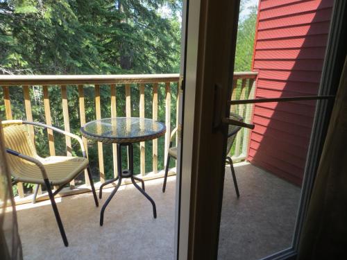 a patio with a table and chairs on a balcony at Village Creek Country Inn in Westerose