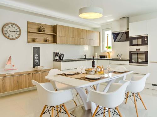 a kitchen with a white table and white chairs at Apartment ViD by Interhome in Vantačići