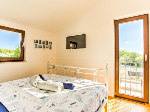 a bedroom with a bed and a window at Holiday Home Villa Willheim in Sveti Ivan Dobrinjski
