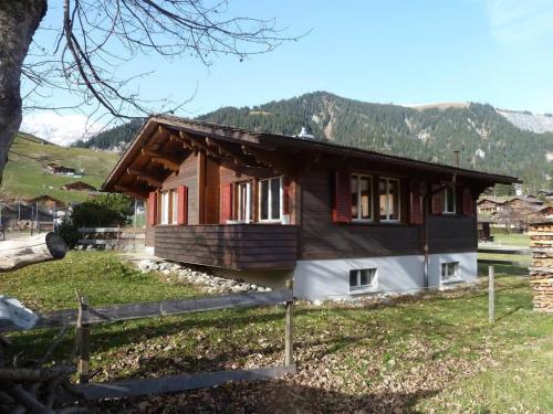 a small house in a field with mountains in the background at Apartment Bodehus by Interhome in Adelboden