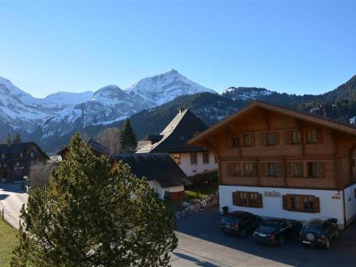 un edificio con coches estacionados frente a él con montañas en Apartment Lydia by Interhome, en Lauenen