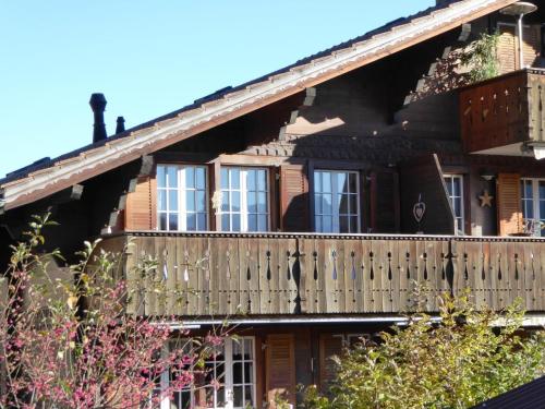 een houten huis met een balkon aan de zijkant bij Apartment Résidence Sonnegg - Herrli by Interhome in Zweisimmen