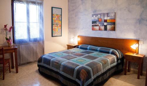 a bedroom with a bed and two tables and a window at Sant'Anna affittacamere in Alghero