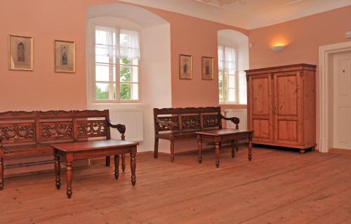 a living room with two benches and a cabinet at Penzion na Faře in Dubenec