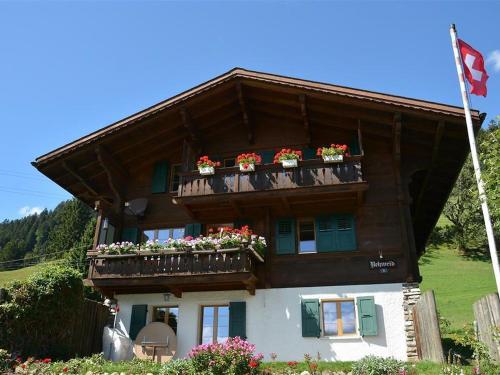a house with flower boxes on the balcony of it at Apartment Rehweid - 2- Stock by Interhome in Gstaad