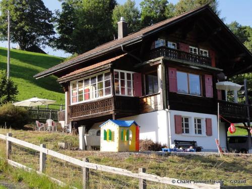 a small house with a balcony on a field at Apartment Sonnenfreude- Chalet by Interhome in Schönried