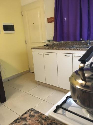 una cocina con armarios blancos y una olla en la estufa en Deptos Drei Kinder, en Belén de Escobar