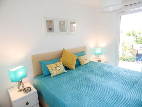 a bedroom with a blue bed with two lamps at Apartment Cap Marine-2 by Interhome in Cavalaire-sur-Mer