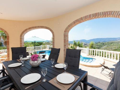 uma sala de jantar com mesa e cadeiras e uma piscina em Villa Capi by Interhome em Monte Pego