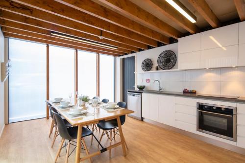 a kitchen with a wooden table and chairs at Koura Apartments Central Queenstown in Queenstown