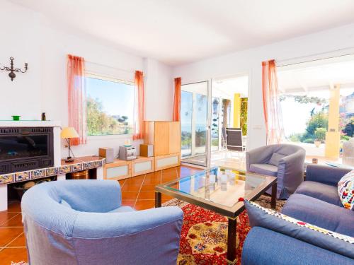 a living room with blue chairs and a tv at Holiday Home Esmerdo by Interhome in Estepona