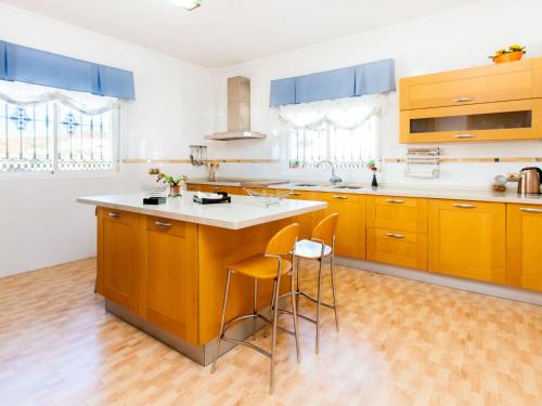 cocina con armarios amarillos y encimera blanca en Holiday Home Tulipán by Interhome, en Rincón de la Victoria
