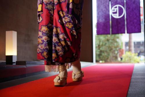 a woman in a dress walking on a red carpet at Hotel Kuu Kyoto in Kyoto