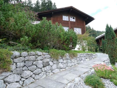 a stone retaining wall in front of a house at Apartment Weidli- Chalet by Interhome in Zweisimmen