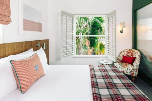 a bedroom with a bed and a window and a chair at Palihotel Culver City in Los Angeles