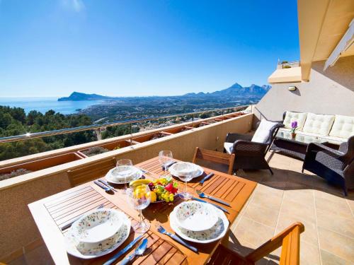 a table on a balcony with a view of the ocean at Apartment Villa Marina Golf-1 by Interhome in Altea la Vieja