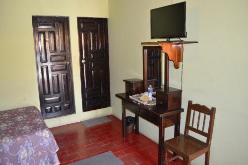 a room with a bed and a television and a chair at Hotel Dos Rios in Guanajuato