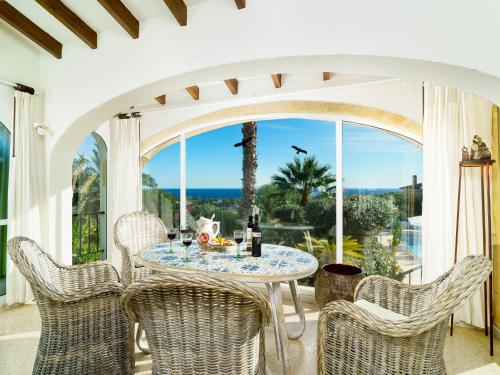 a dining room with a table and chairs and a large window at Holiday Home Las Boyas by Interhome in Moraira