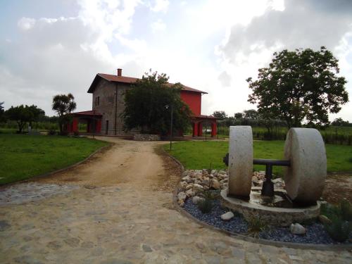 a stone bench in front of a building with a dirt road at Agrituirsmo Masseria Campierti in Falciano del Massico