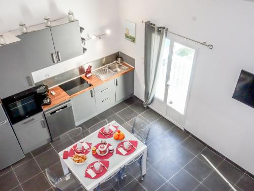 une cuisine avec une table et des assiettes de nourriture dans l'établissement Apartment La maison d'Adélaïde by Interhome, à Aigues-Mortes
