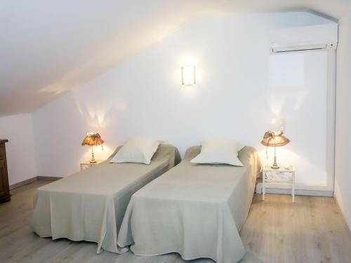 - 2 lits dans une chambre blanche avec 2 lampes dans l'établissement Apartment La maison d'Adélaïde by Interhome, à Aigues-Mortes