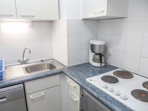 une cuisine blanche avec un évier et une cuisinière dans l'établissement Studio Le Nadir-3 by Interhome, à Fréjus