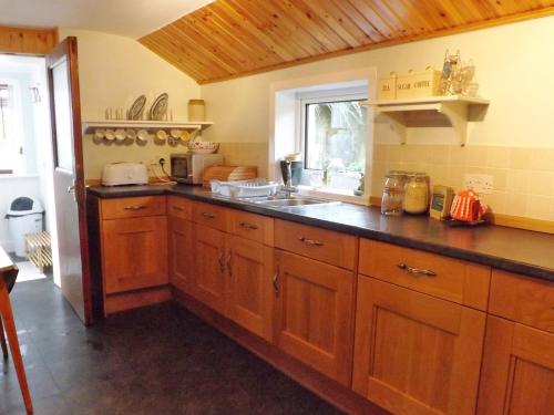 a kitchen with wooden cabinets and a sink at Holiday Home Harlosh by Interhome in Roag