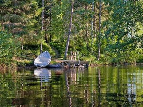ein Boot neben einem Dock auf einem See in der Unterkunft Holiday Home Metsäpirtti by Interhome in Pätiälä