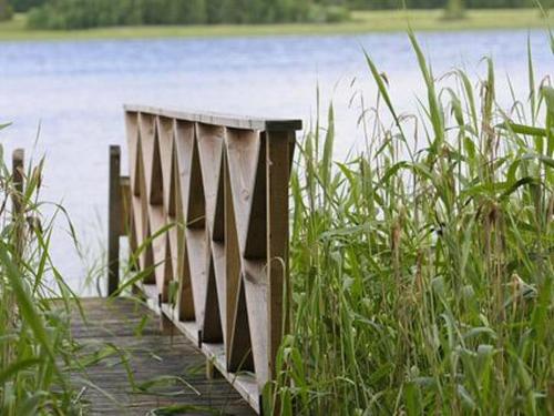 un puente de madera sobre un cuerpo de agua en Holiday Home Divaanikivi by Interhome, en Pätiälä