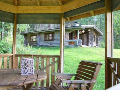 eine Veranda mit einem Holztisch und 2 Stühlen in der Unterkunft Holiday Home Peltotupa by Interhome in Pätiälä