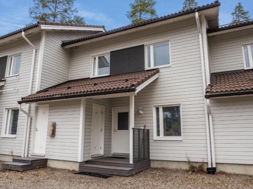 ein weißes Haus mit einer Veranda in der Unterkunft Holiday Home Vuokatinlampi 7 b by Interhome in Lahdenperä